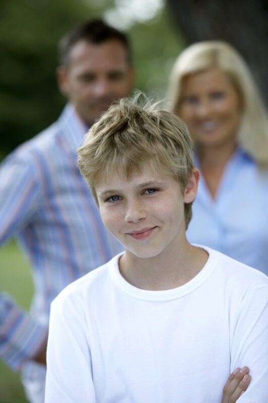 Family with child smiling confidently after pediatric growth hormone telehealth treatment with I Grow Clinic, representing hope and full growth potential for children with idiopathic short stature