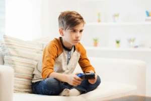 Child sitting at a desk with slouched posture, showing rounded shoulders and forward head position.