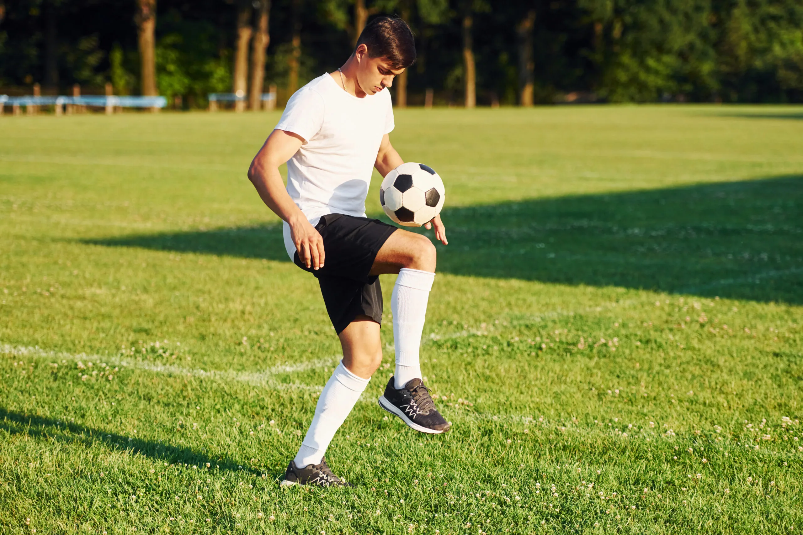 Teenage boy exercising outdoors with a soccer ball to support strength and healthy growth.