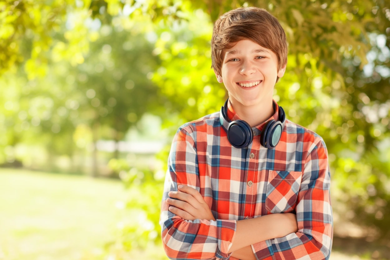 Confident teenage boy smiling outdoors after growth evaluation, symbolizing healthy development.