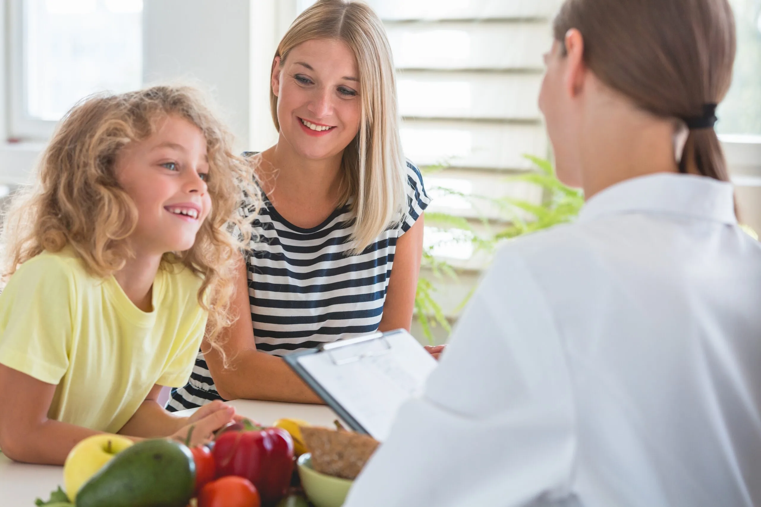 Pediatrician talking with a mother and child about healthy eating for better growth.