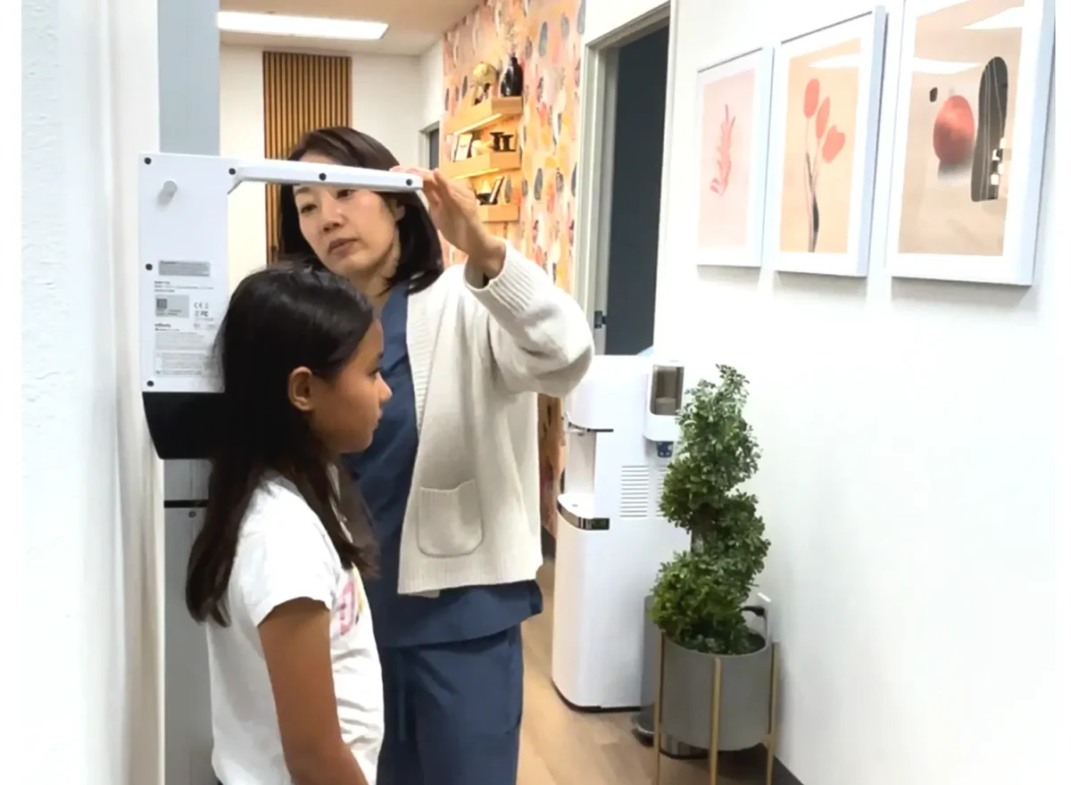 At I Grow Clinic in Fullerton, a healthcare professional carefully measures a child's height as part of a comprehensive safety protocol to monitor growth hormone therapy and minimize potential side effects.