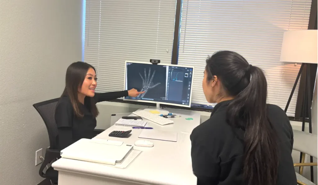 A provider at I Grow Clinic reviewing a bone age X-ray with a patient during a growth evaluation.