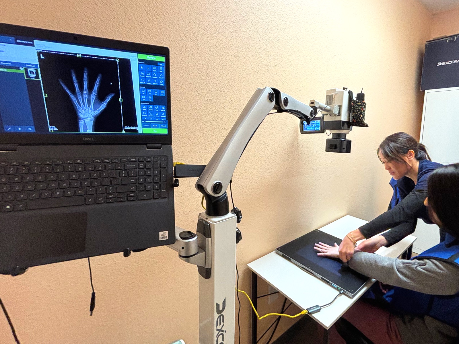 Bone age X-ray device scanning a child's hand at I Grow Clinic for skeletal maturity evaluation