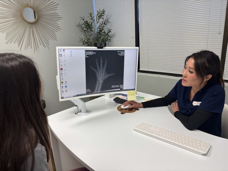 Nurse practitioner at I Grow Clinic reviewing bone age X-ray results with a parent during a growth evaluation