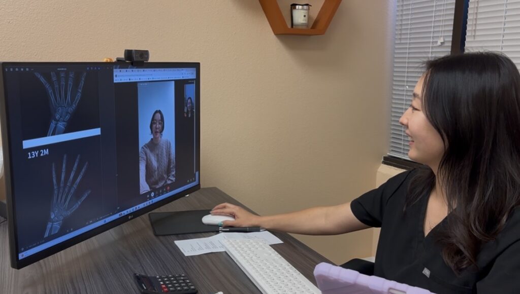 NP at I Grow Clinic conducts a telehealth bone age consultation with bone age X-ray on screen